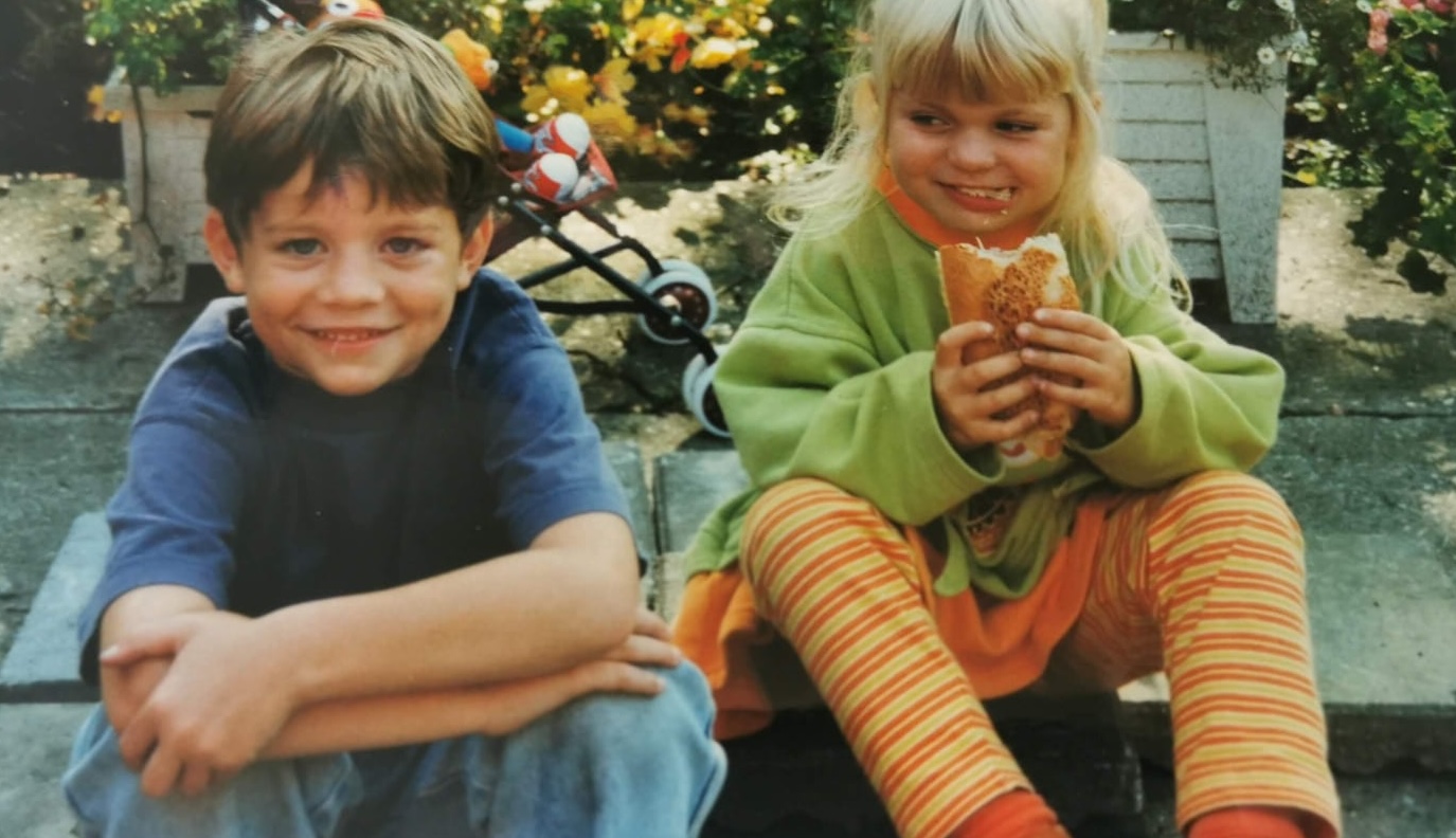 Twee kinderen zitten buiten te eten